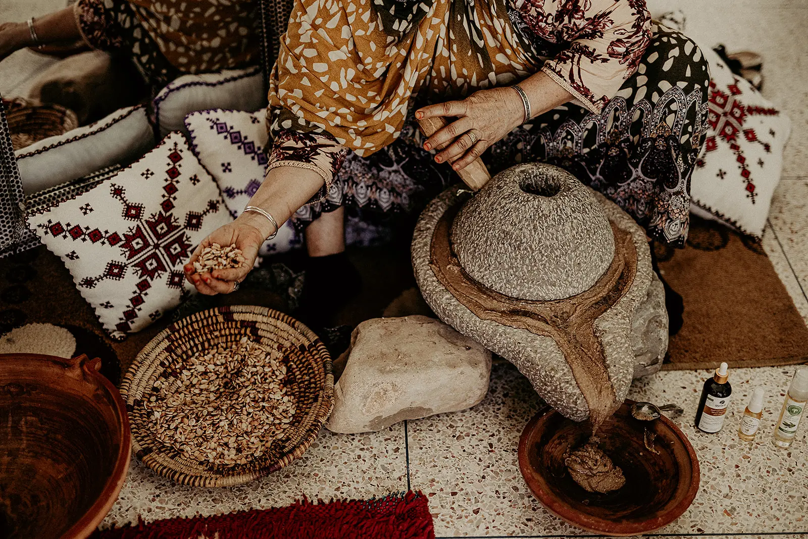 Picture of a woman från Nuni Global holding in raw argan nuts, to make argan oil.